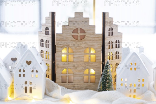 Cozy Christmas decor tiny house of small size on window sill with snow outside the window. Gift for New Year. Insurance, moving to new house, mortgage, rent and purchase real estate