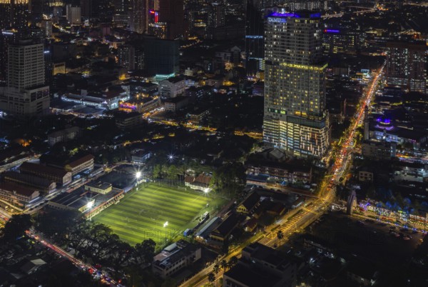 A picture of the EV Arena Kelab Sultan Sulaiman football field, and the Tamu Hotel and Suites Kuala Lumpur, at night