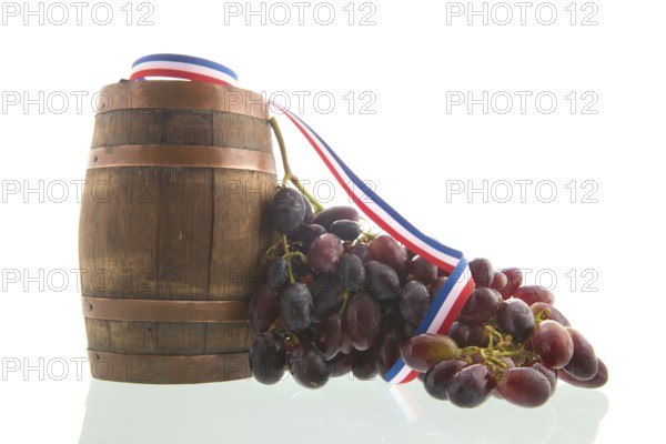 Old wooden wine barrel and buch of red grapes isolated over white background