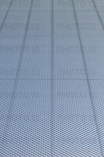 Closeup of metal mesh on concrete wall background texture