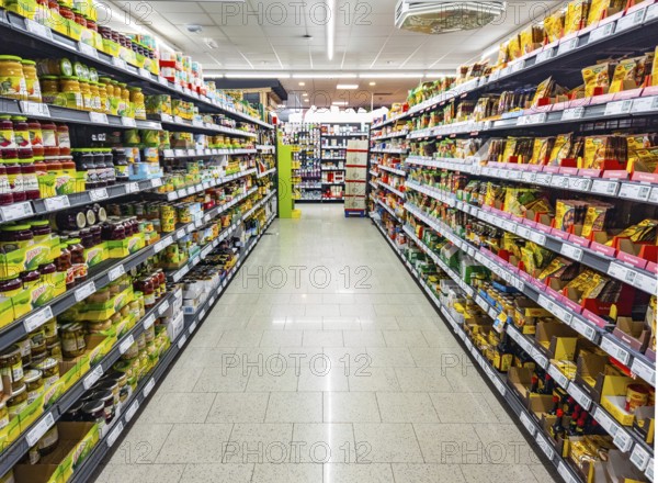 HUETTENBERG, HESSE, Germany_ 12_05_2022: Aisle with shelves full of food products in a German supermarket