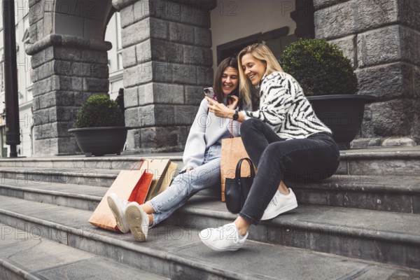 Two young caucasian women having fun on city street outdoors, Best friends enjoying a holiday day out together, Happy lifestyle, youth and young females concept.