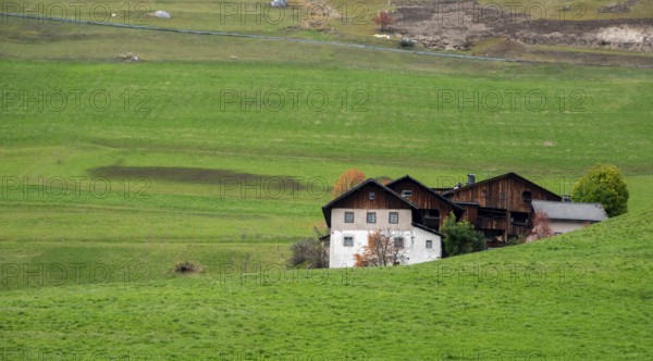 Traditional wooden cottage mountain houses in the green field in the dolomites. Housing in costadedoi Italian apls. Alpine region