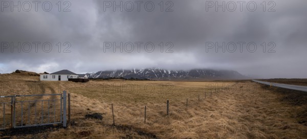 Icelandic landscape at winter. Farmland field, farmhouse stormy cloudy sky Iceland europe