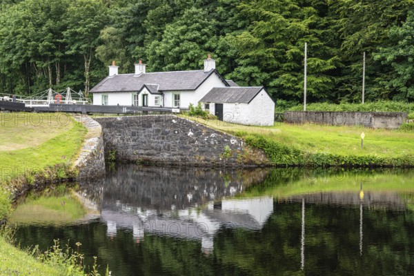 Lock Keepers Cottage reflected in the pool below lock 11, Argyll and Bute, Scotland, United Kingdom