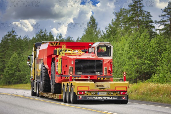 Yellow Volvo FH16 semi trailer Mantyla E&E Ky hauls Sandvik underground truck for mining operations on highway 25. Raasepori, Finland. July 24, 2020