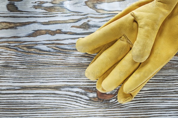 Leather protective gloves on wooden board