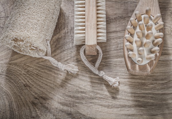 Composition of scrubbing loofah massager bath brush on wooden board spa treatment concept