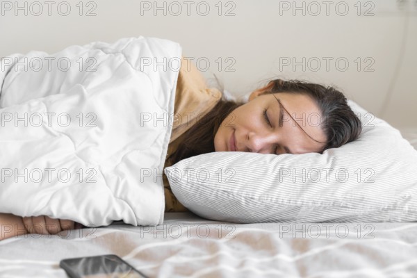 Young woman goes to sleep Phone addiction, insomnia. try to fall asleep. Sleep tracking on the phone. Circadian rhythm. High quality 4k footage