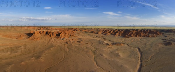 Aerial panorama view of the Bayanzag flaming cliffs at sunset in Mongolia, found in the Gobi Desert