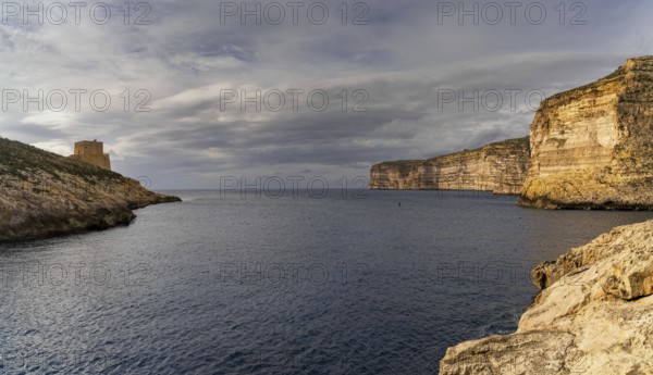 A view of the Xlendi Bay watchtower and cliffs on the coast of Gozo Island in Malta