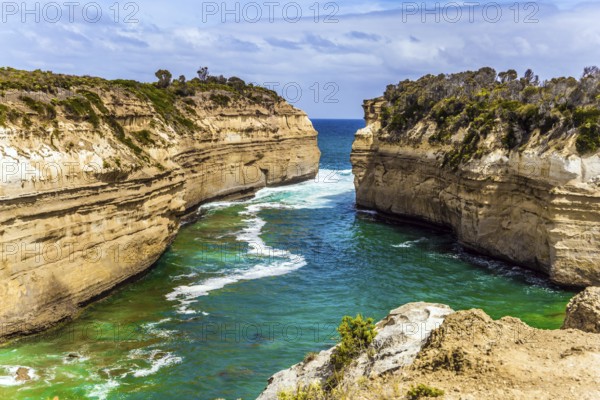The Great Ocean Road of Australia. Coastal rocks are composed of sandstone. Small ocean fjord with clear green water. The concept of exotic, active and photo-tourism