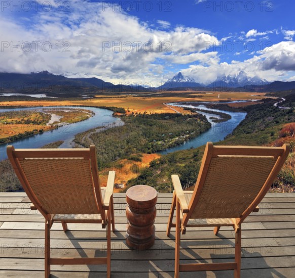Two wooden chairs - on a wooden platform. Charming rural idyll. Clouds reflected in the smooth water of the river. A comfortable place to enjoy the beauty of the landscape