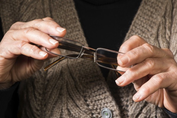 Old women hands hold glasses