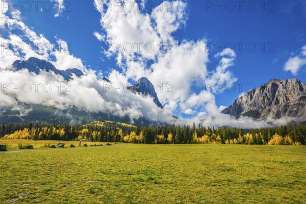 Shining sunny day in Canmore. Concept of hiking. The Three Sisters mountains in the Canadian Rockies