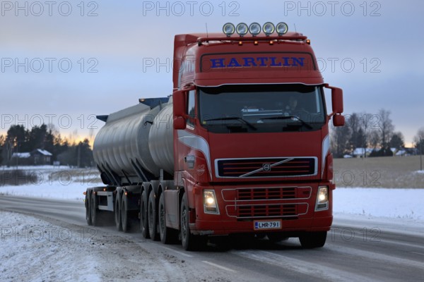 SALO, FINLAND, JANUARY 15, 2017: Red Volvo FH tank truck for bulk transport delivers a load along highway at dusk in winter
