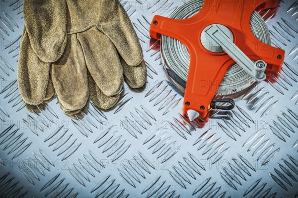 Leather safety gloves measuring tape on fluted metal sheet