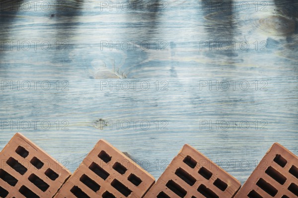 Red bricks on wooden board horizontal version building concept
