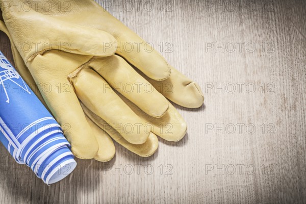 Protective gloves blue blueprints on wooden board construction concept
