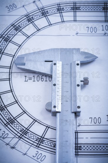 Stainless slide caliper on blueprint vertical view construction concept