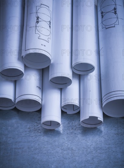 Heap of engineering drawings on scratched metallic background building and architecture concept