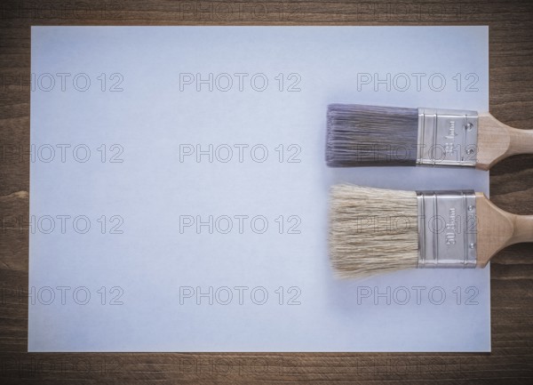 Clean sheet of paper and paintbrushes top view image