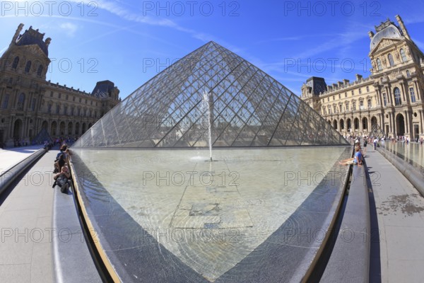 Paris, September 8: The world-famous entrance to the Louvre - the glass pyramid and a spectacular fountain of September 8, 2012 in Paris