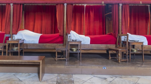 Beaune, France - April 29, 2024: Interior of main room with red beds at Hospices de Beaune or Hotel-Dieu de Beaune a former charitable almshouse in ancient town Beaune in Burgundy region in France