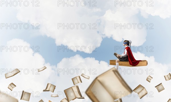 Girl power concept with cute kid guardian against cloudscape background