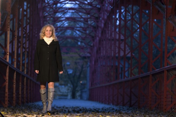 Portrait of a middle-aged, curly-haired blonde woman at dusk