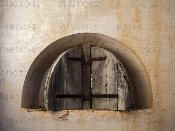 A picture of a rusty window of an abandoned fortress