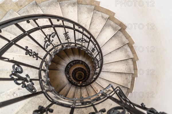 High angle view of spiral staircase with hand of man below