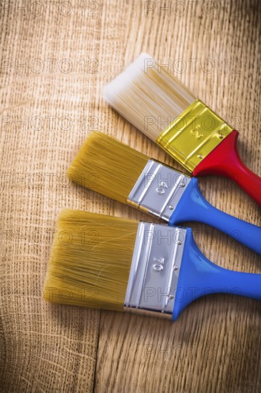Three paint brushes on wooden board construction concept