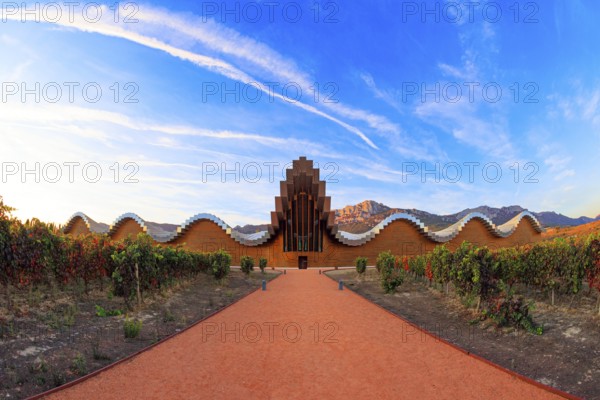 The magnificent modern architecture of Bodegas Ysios. Bright flaming colors of the sunset. Journey to the warm Spanish autumn. Fantastic beauty