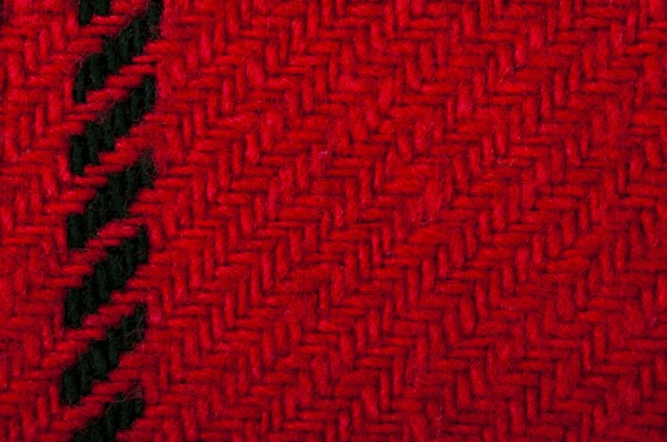 Handmade knit black and red background. Close up structure of the yarn. Christmas colors
