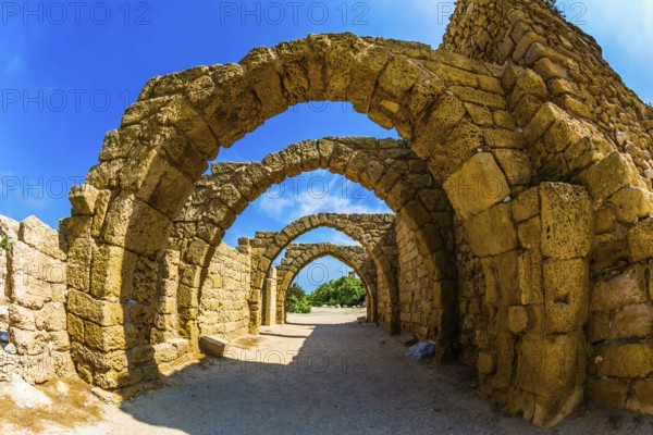 Picturesque ruins of the ancient seaport Caesarea. Excursion to the Archaeological Park of the Roman Empire. Sunny spring day. Concept of ecological and historical tourism