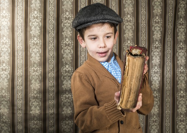Child with red vintage book. Vintage clothes and hat