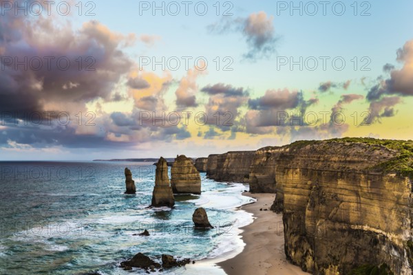 Early morning on the ocean shore. Pink dawn clouds over the famous rocks Twelve Apostles. Travel to Australia. The concept of active, ecological and photo tourism