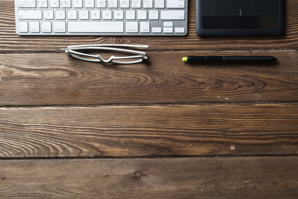 Top view office workspace composition. Flat lay vintage wooden desk with pc keyboard and graphic drawing tablet. Design and creativity. Time management and planning. Designer workplace organization