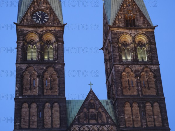 Detailed view of two Gothic church towers with clocks, illuminated in the soft evening mood, Bremen, Germany