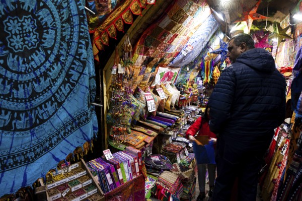 A vibrant market stall showcasing colorful textiles and tapestries in the London Borough of Camden, Greater London, United Kingdom