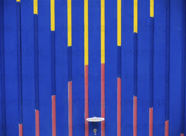 Garage door with graphic pattern in the colours blue, red and yellow, format-filling