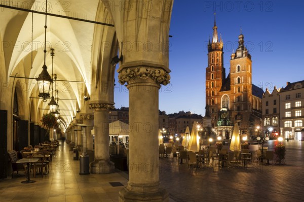 City of Krakow by night in Poland, Main Square in the Old Town with St. Mary Church from the arcade of the Coth Hall (Sukiennice)
