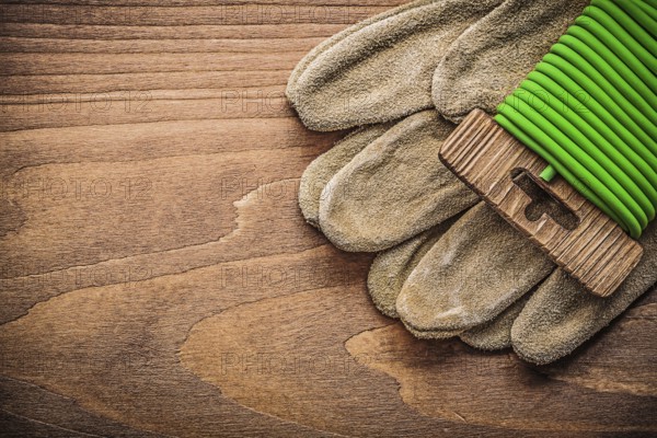 Garden tie wire leather safety gloves on wooden board gardening concept