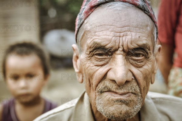 Damak, Nepal, circa May 2012: Old frowning man with beard and wrinkles on his face at Nepali refugee camp in Damak, Nepal. Documentary editorial