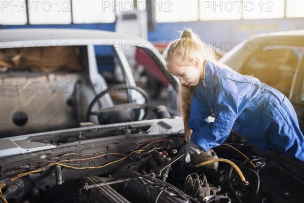 Little girl repairing car with spanner