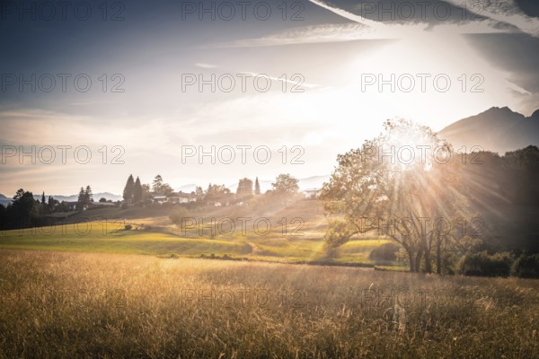 Scenic sunset view over meadow, hills and mountains