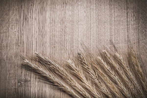 Golden wheat rye ears on wooden board horizontal version food and drink concept
