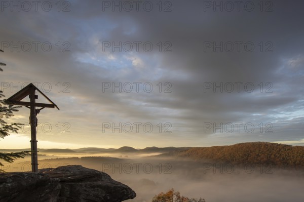 Mystical sunrise at the Wachtfelsen. Fascinating landscape shot between fog and clouds near Wernersberg, Pfälzerwald, Germany