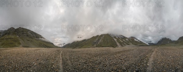 Panoramic view of hiking trail in glacial valley high up in Kashmir mountains in India on cloudy day